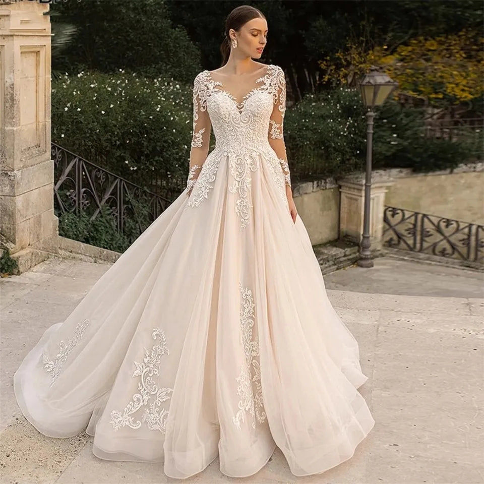 Abito da sposa di lusso con maniche lunghe in pizzo, applicazioni in tulle trasparente, schiena scoperta e gonna a-linea - Bridetobe.it