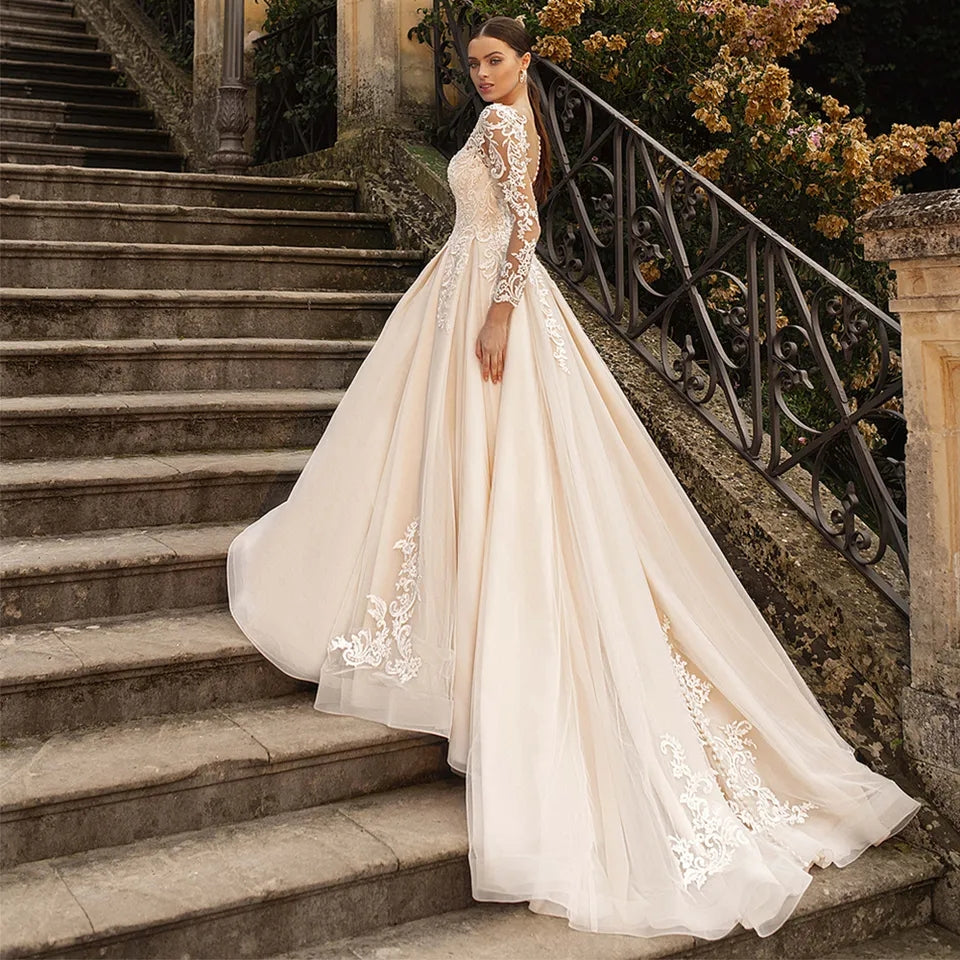 Abito da sposa di lusso con maniche lunghe in pizzo, applicazioni in tulle trasparente, schiena scoperta e gonna a-linea - Bridetobe.it