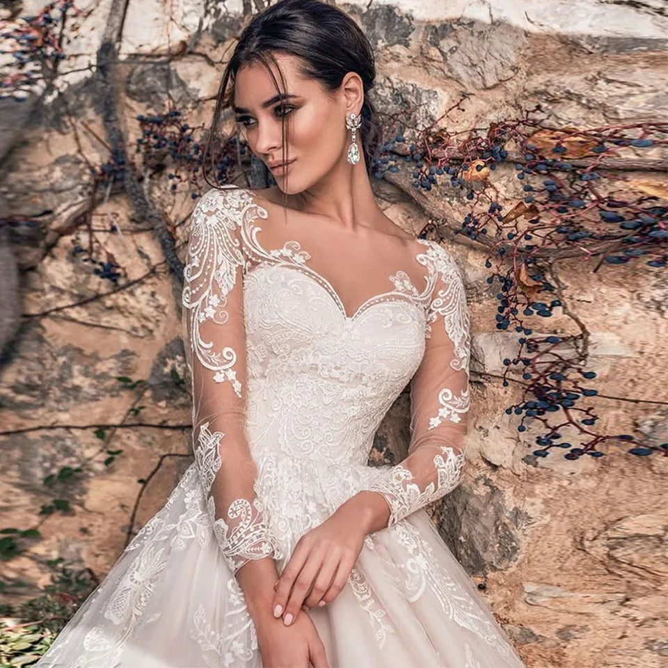 Abito da sposa a linea A in tulle con scollo a barca vintage, maniche lunghe trasparenti, applicazioni e strascico, modello Sexy Illusion, lusso 2023.