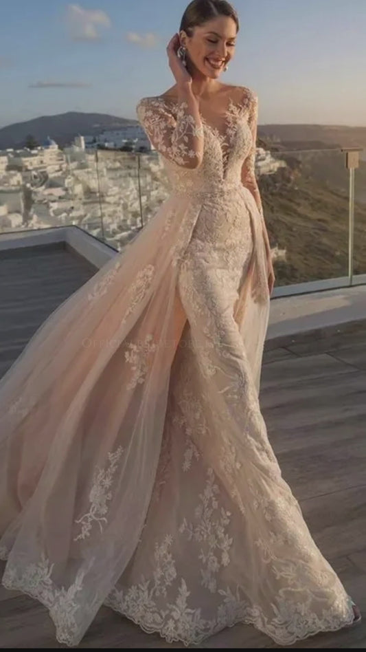 Robe de mariée sirène avec décolleté illusion, manches longues en dentelle et détails luxueux