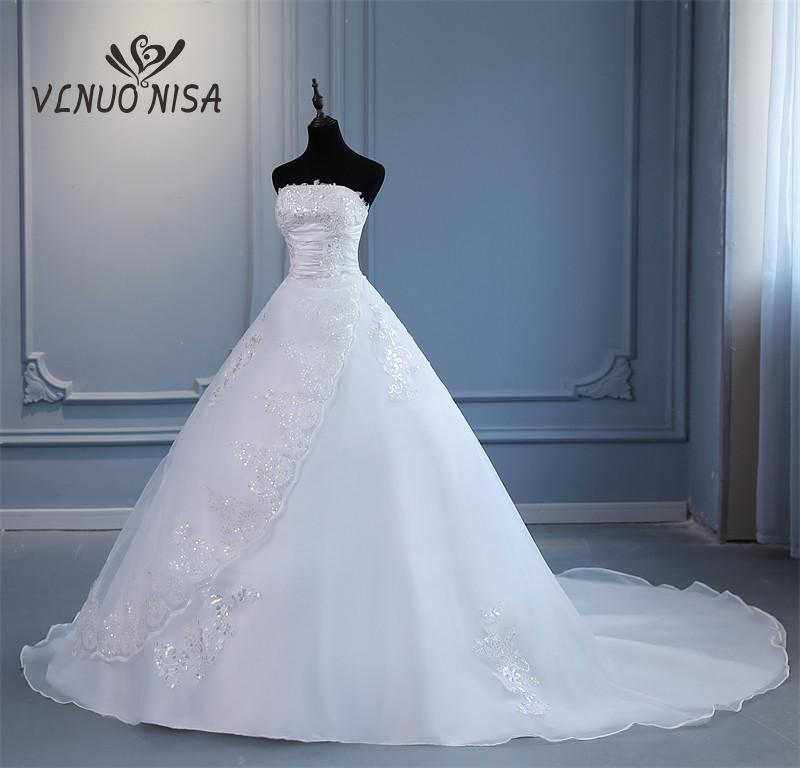 Abito da sposa principessa con strascico lungo senza spalline e con pizzo ricami e paillettes